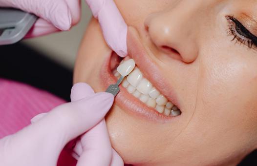 Dentysta przymierza implant stomatologiczny do uzębienia pacjentki