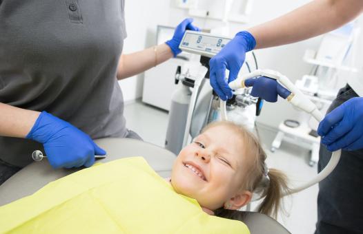 Uśmiechnięta dziewczyna na fotelu dentystycznym